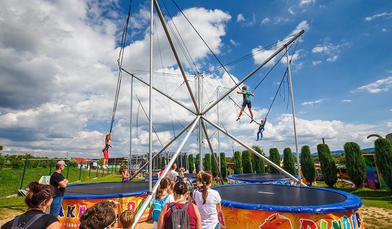 Dzieci skaczące na trampolinach.