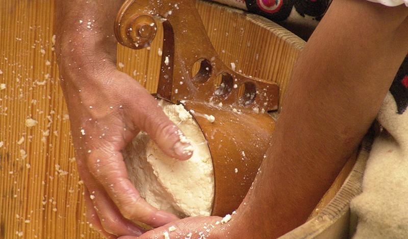 Formowanie oscypka, ser przeciskany przez drewnianą formę