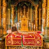 Wnętrze drewnianej cerkwi. Ołtarz z kolumnami, złoceniami, rzeźbami i ikonami.