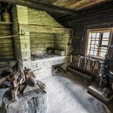 Drewniane wnętrze kuźni z Michalczowej z piecem z kamieni, szerokim pniakiem z imadłem oraz innymi narzędziami niezbędnymi do podkuwania koni. Po prawej stronie pieca znajduje się okno.