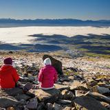 Dwoje turystów siedzi na skałach na szczycie Babiej Góry