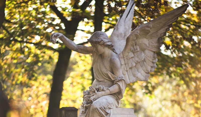 Kamienna rzeźba anioła na nagrobku.