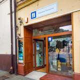 Oszklone drzwi wejściowe do Punktu Informacji Turystycznej w Andrychowie, wewnątrz widać stojak z wydawnictwami Małopolskiego Systemu Informacji Turystycznej