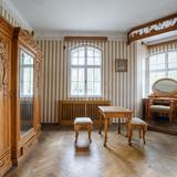 Wnętrze willi, pokój ze ścianami w pionowe pasy, wyposażony w dużą drewnianą szafę i toaletkę.
