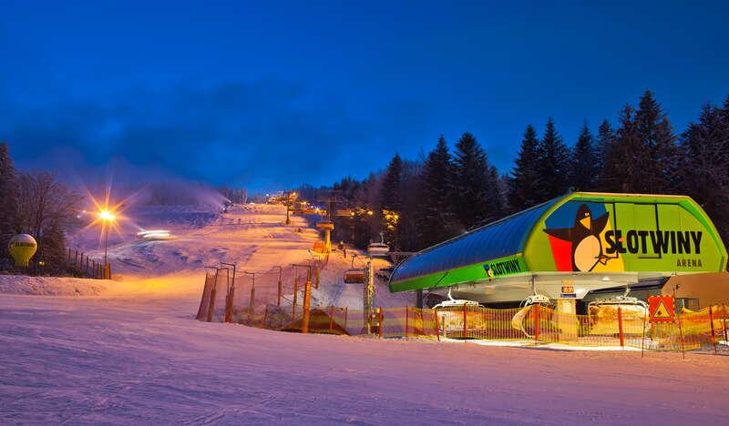 Widok na wyciąg krzesełkowy stacji narciarskiej Słotwiny Arena w zimowy wieczór