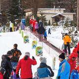 Grupa narciarzy i dzieci korzystających z przenośnika taśmowego i wyciągu SunKid na stacji narciarskiej RyterSki