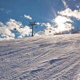 Widok na stok narciarski  i wyciąg krzesełkowy na stacji narciarskiej RyterSki w zimowy słoneczny dzień