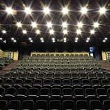 Sala konferencyjna w układzie teatralnym z kilkunastoma rzędami foteli widziana od dołu