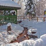 Mofeta w Tyliczu obsypana śniegiem, obok stojąca zielona, drewniana altana.