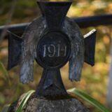 Część metalowego krzyża z napisem 1914.