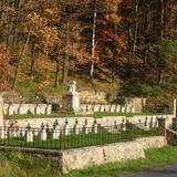 Widok na cmentarz z kamiennymi nagrobkami i pomnikiem.