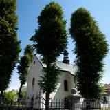 Kościół za drzewami i ogrodzeniem.