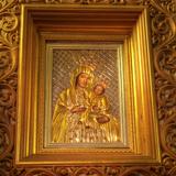Cudowny obraz Matki Bożej w złotej sukience i ozdobnej złoconej ramie.