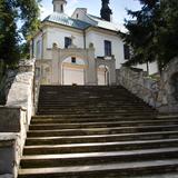 Na pierwszym planie widać wysokie schody prowadzące do fasady kościoła.