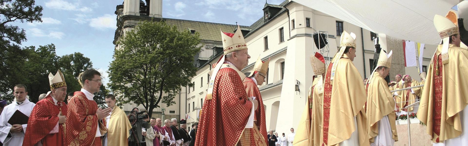 Grupa księży idących w stronę ołtarza.