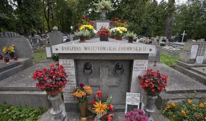 Grób Wojtyłów, kamienny, wokół kwiaty i znicze.
